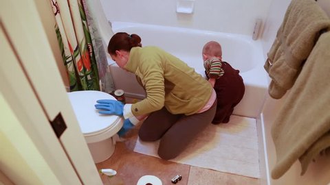A mother and her toddler cleaning the bathroom in the house