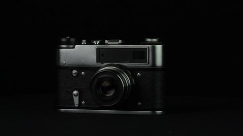 Old photo camera rotates on a black background loop