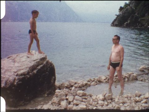 Boy jumping from rock into fathers arms (vintage 8 mm amateur film) Stockvideo