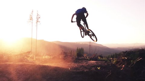 Mountain biker jumping at sunset in super slow motion