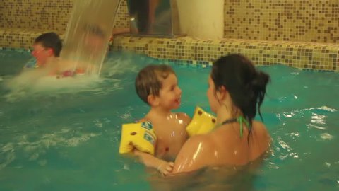 Mom and son swimming in a small pool

