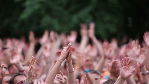 MOSCOW, RUSSIA - JUNE 23, 2012: People raise their hands up and applaud at a concert of Chaif rock-band during VII traditional festival of live sound Music of Summer in Hermitage Garden