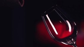 Red Wine Pouring into Glass. Black Background. Slow Motion Shot 240fps