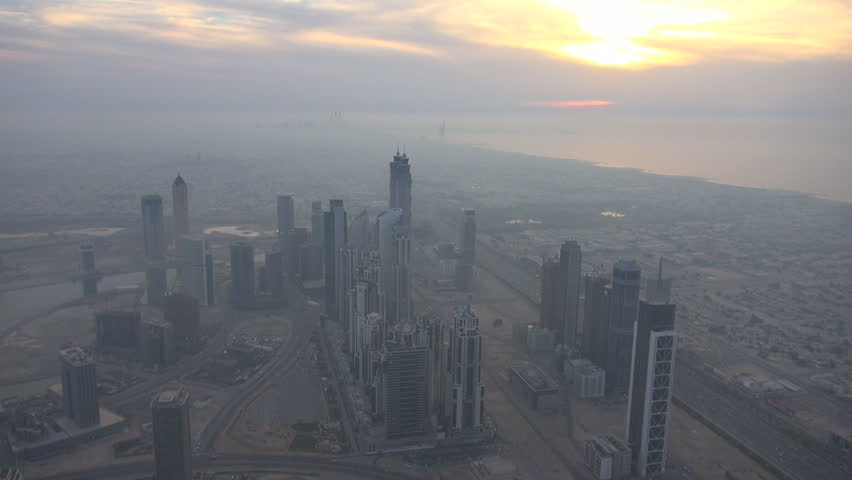 DUBAI, UAE - JANUARY 25, 2014, Panoramic view of business building and Burj Al Arab hotel, skyscraper tower in foggy day at sunset