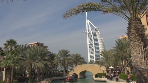 DUBAI, UAE - JANUARY 25, 2014, Burj Al Arab among palm tree of a beautiful resort by day