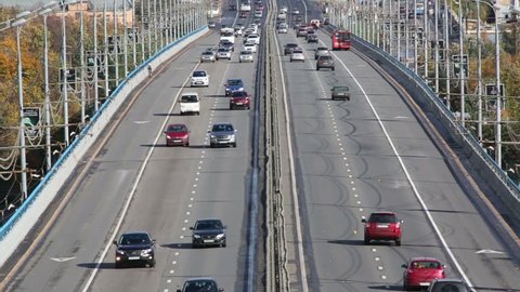 Many modern cars go on bridge at sunny day in Moscow, Russia