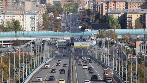 Many modern cars go on bridge at autumn day in Moscow, Russia