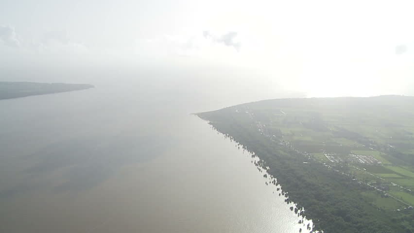 Plane flying over ocean and river in Guyana