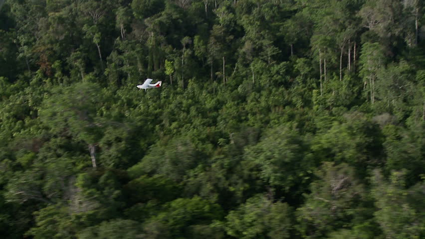 Bush plane lands on short dirt runway from the air