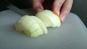 A peeled onion being cut on pieces high definition footage  - Onion cutting footage in FullHD 1920X1080