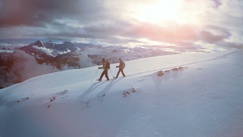 hiking in the snow. hikers walking. foot feet steeps. snow winter landscape. sports recreation activity. holiday vacation tourism. people persons male silhouette. fly over. aerial