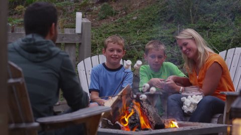 Family roasting marshmallows by outdoor fire. Shot on RED EPIC for high quality 4K, UHD, Ultra HD resolution.