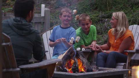 Family roasting marshmallows by outdoor fire. Shot on RED EPIC for high quality 4K, UHD, Ultra HD resolution.