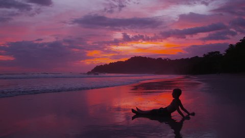 Young boys sitting on beach at sunset, Costa Rica. Shot on RED EPIC for high quality 4K, UHD, Ultra HD resolution. : vidéo de stock