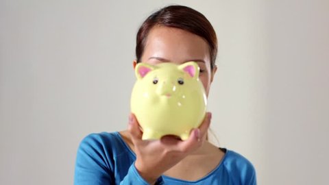 Young people and money, portrait of asian woman holding piggybank and 1 euro coin for savings