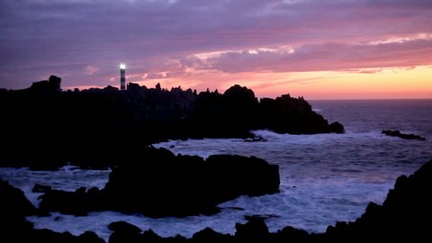 beautiful sunset on coastline with powerful lighted lighthouse, ouessant island, brittany, france 