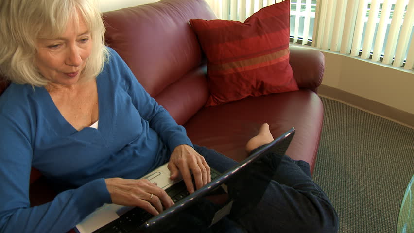 senior woman on couch with laptop