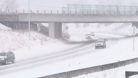 PORTLAND, OREGON - CIRCA 2014: Traffic driving along freeway during intense snow storm with city train running through frame.