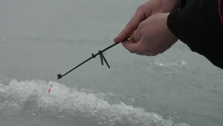 Fishing rod on the river in winter on the ice near the hole