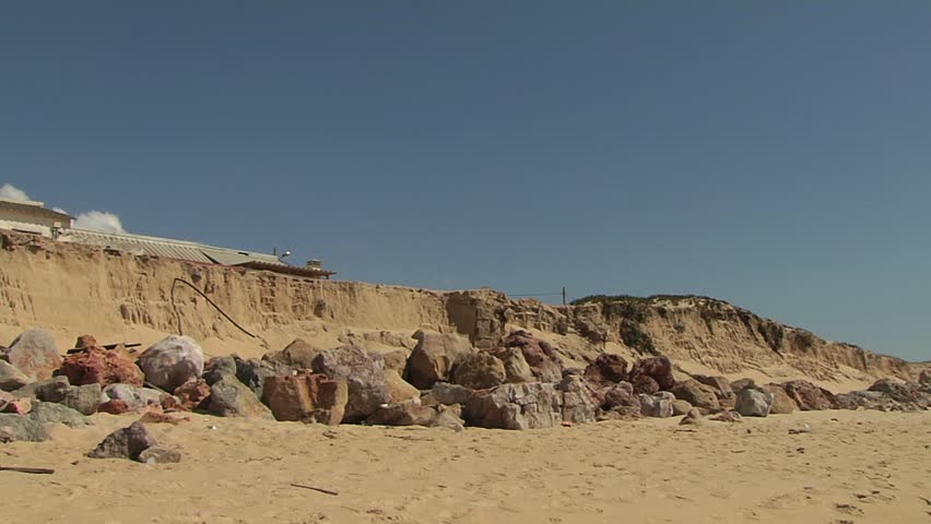 Makeshift homes on rocky terrain by beach