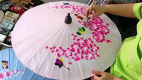 Artist painting on umbrella for tourists in Chiang Mai, Thailand