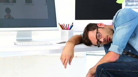 Photo editor sleeping at his desk in creative office