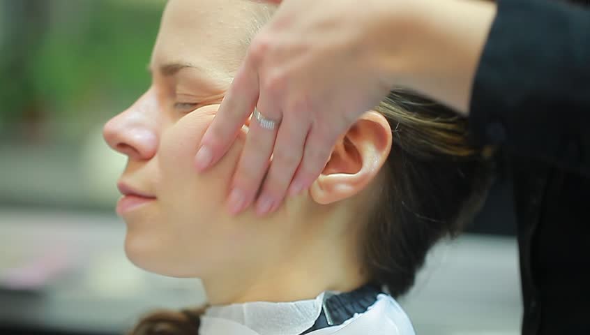 applying makeup on female face