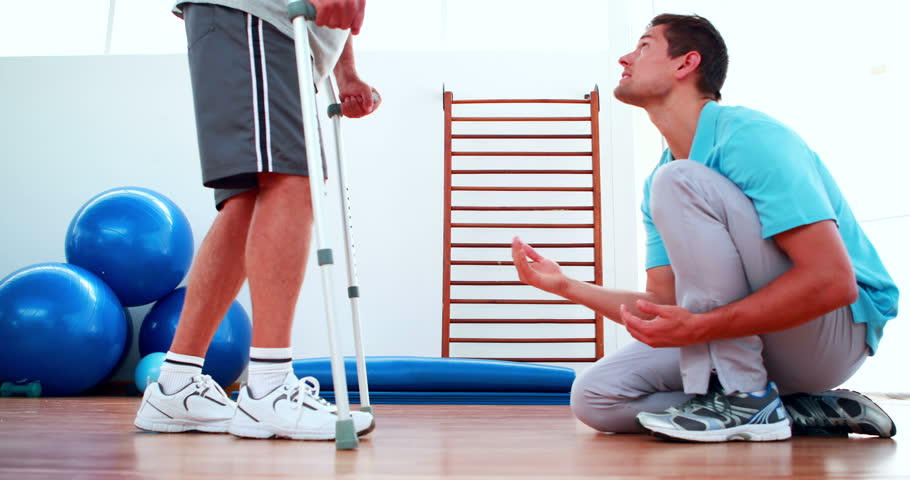 Physiotherapist helping patient walk with crutches at the rehabilitation center Royalty-Free Stock Footage #5653115