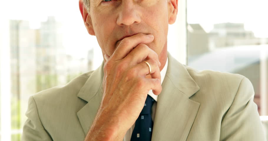 Thinking businessman looking at camera in his office Royalty-Free Stock Footage #5653670