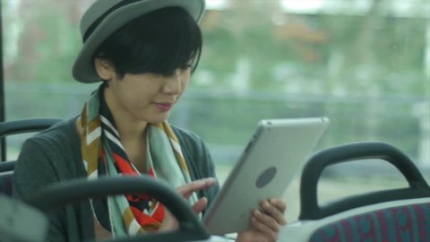 Pretty Young Asian Woman Using A Digital Tablet On A Train