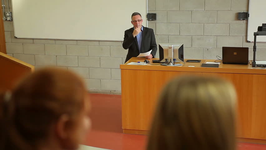 Lecturer explaining something to class in lecture hall at the university