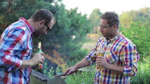 men preparing grill and drinking beer
 Arkivvideo