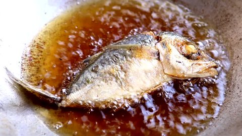 frying mackerel fish in pan with vegetable oil
