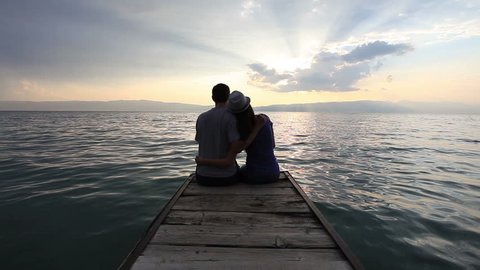 Young heterosexual couple kissing at the beach on sunset స్టాక్ వీడియో