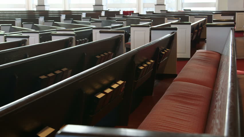 Close-up shot slowly tracking (dollying) past wooden pews in a Christian church. | Shutterstock HD Video #5687441