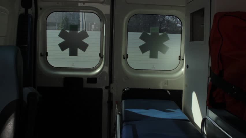 Medical team takes out stretcher from ambulance to transport injured patient. Driver opens door and pulls out a gurney. Driver and nurses driving carts for injured patient. Emergency team in action. Royalty-Free Stock Footage #5689835