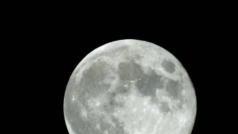 Close up timelapse of moon rising on the dark sky.