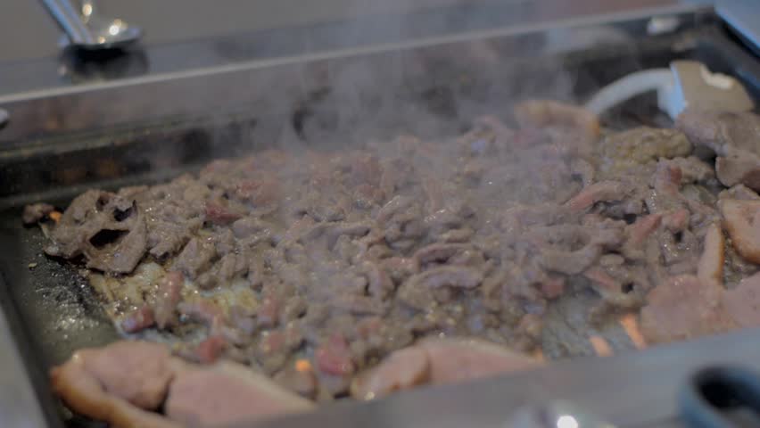 Meat cooking on grill at barbecue restaurant in South Korea