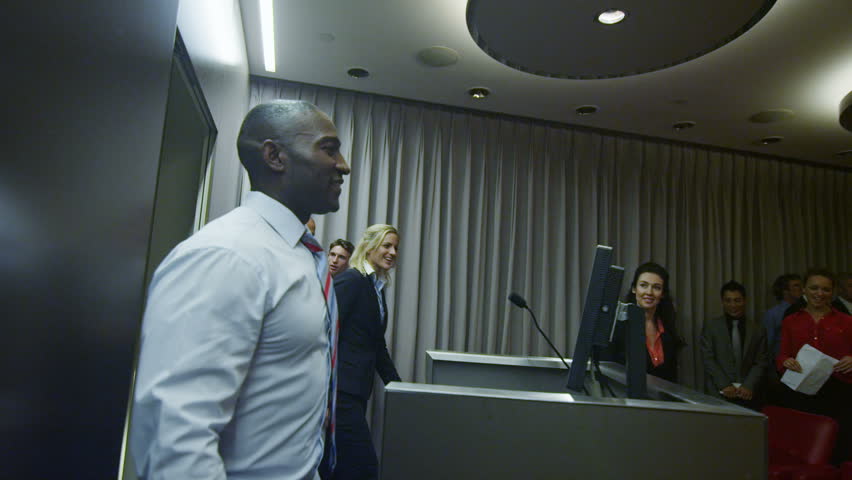 Cheerful diverse business team attending a business presentation or training seminar in company lecture theatre.