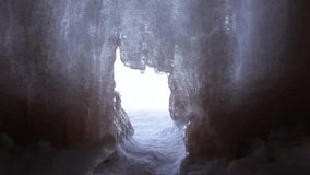 The Apostle Island mainland sea caves as ice caves on frozen Lake Superior, Wisconsin, USA. View from inside a cave, with an opening in the glowing wall of ice and a path leading out onto the lake. - Powered by Shutterstock - Get 15% off with code: PIKWIZARD15