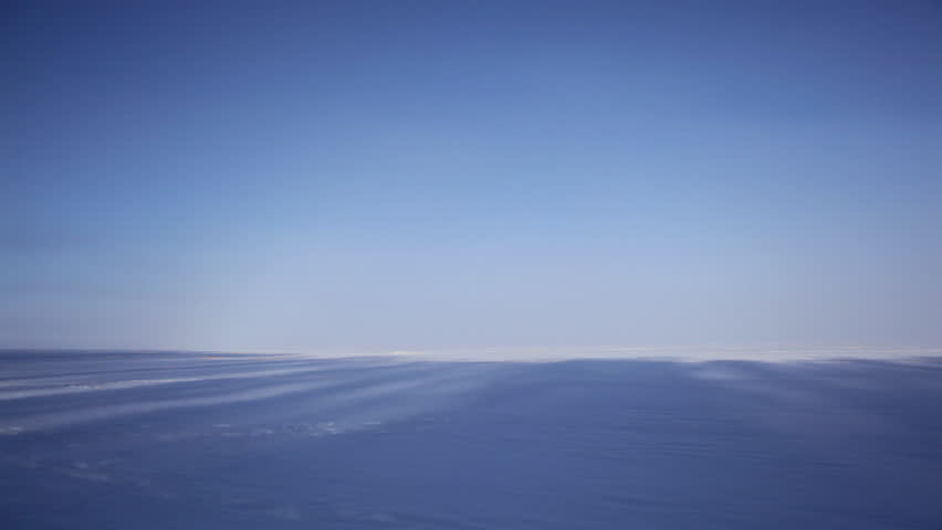 The Apostle Island National Lakeshore on frozen, snow-covered Lake Superior, Wisconsin, Midwest USA. Long shadows fall across the lake towards an unbroken horizon.
