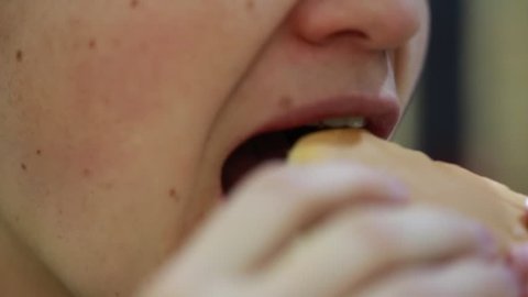 A woman eats a hamburger at a fast-food restaurant