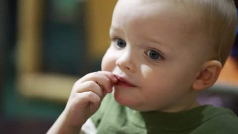 A toddler boy eating his french fries at a fast food restaurant