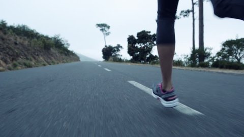 woman running on road close up shoes steadicam shot