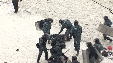 KIEV, UKRAINE - JANUARY 21, 2014: Police beating and arresting protesters doctors during clashes on the street Grushevskogo.