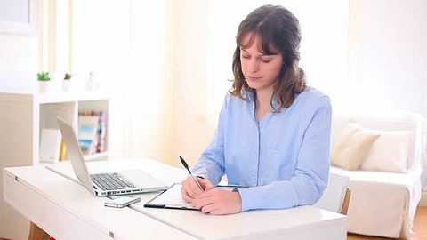 Young attractive business woman copying data on paper 