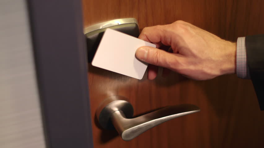 A man in a suit swipes a key card on a secure door and enters the room. Royalty-Free Stock Footage #5723990