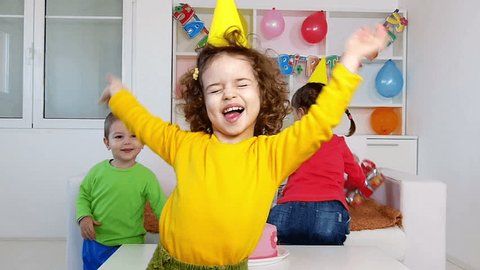 A group of children at a birthday party, smiling and dancing.Slow motion, high speed camera