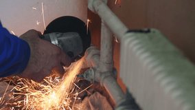 Male hands grinds slice of radiators by angle grinder. Video with sound