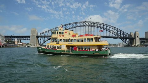 SYDNEY, AUSTRALIA - FEBRUARY 01, 2014: Pan of ferry boat going to Milsons Point, Sydney Harbour bridge and Luna Park.
